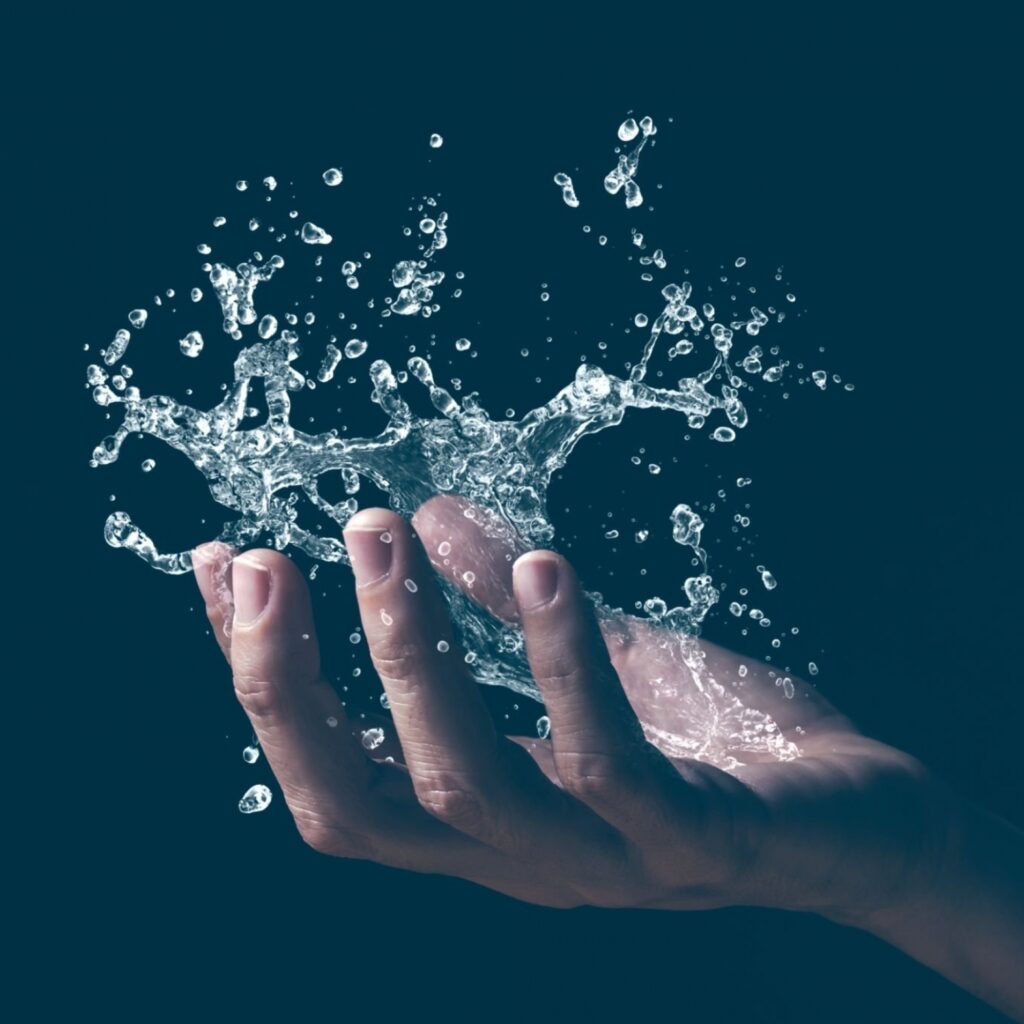 A human hand holding a splash of water